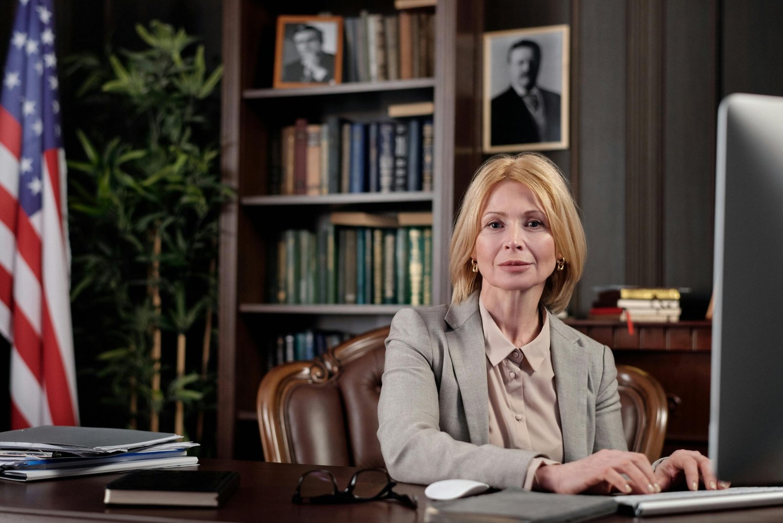 Mature businesswoman at desk in office, portraying leadership and professionalism.